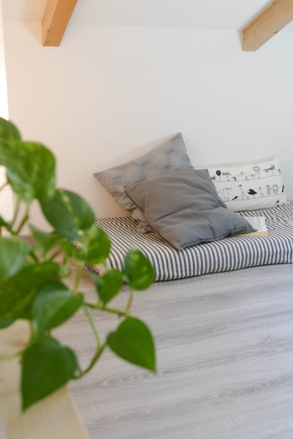 angolo lettura in mansarda creato con un materasso e dei cuscini