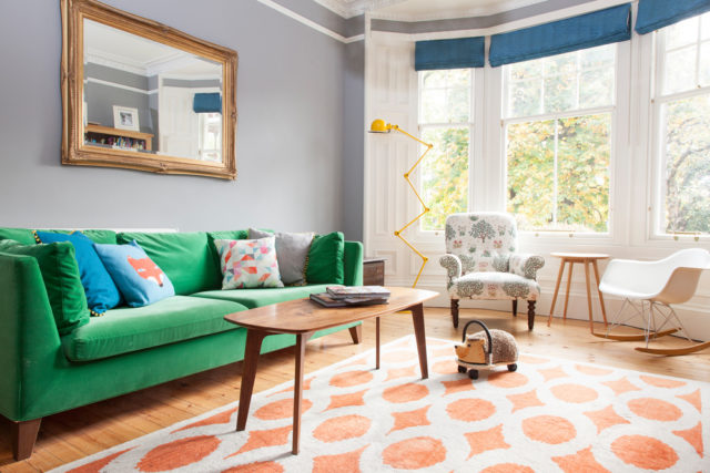 un living pieno di colore grazie al divano verde Ikea al tappeto cuscini a fantasia