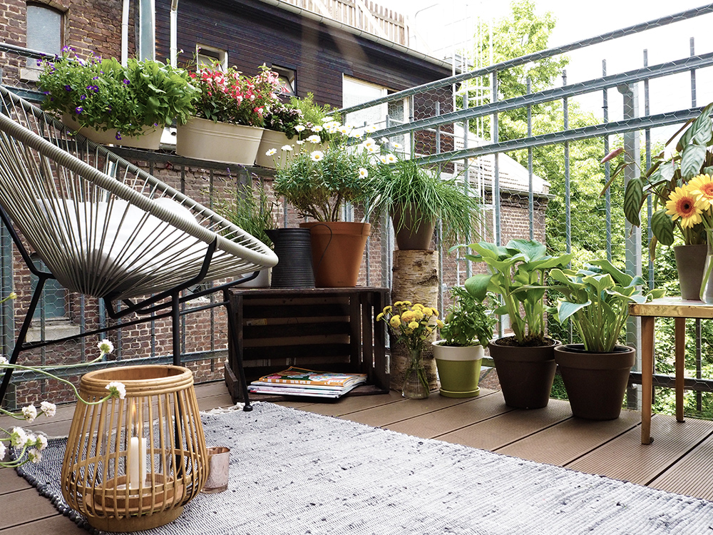 dettaglio del balcone con tappeto lanterne piante e seduta