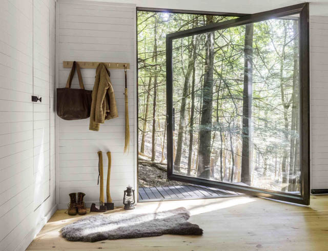 una grande vetrata e tanto legno in questa minimal home nel bosco