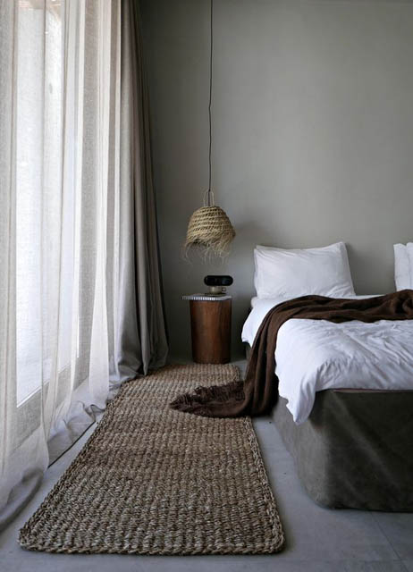 camera da letto con tappeto e lampada in materiale naturale