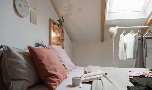 camera da letto con elementi di decoro e rella bianca con abiti