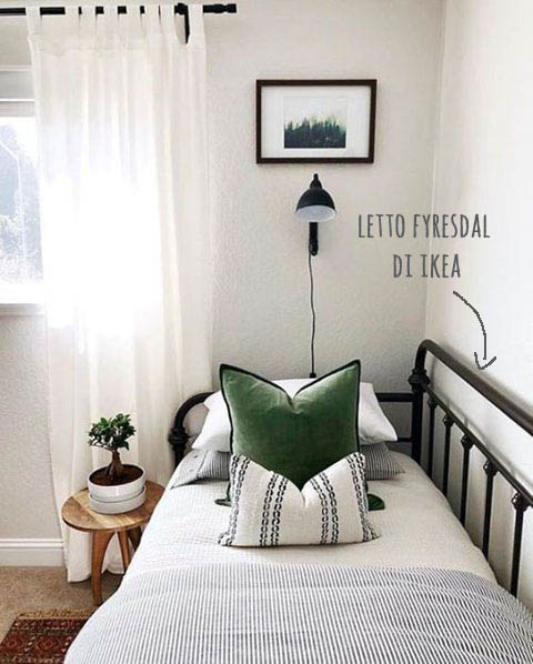 camera ospiti con letto con lenzuola a righe e cuscino verde